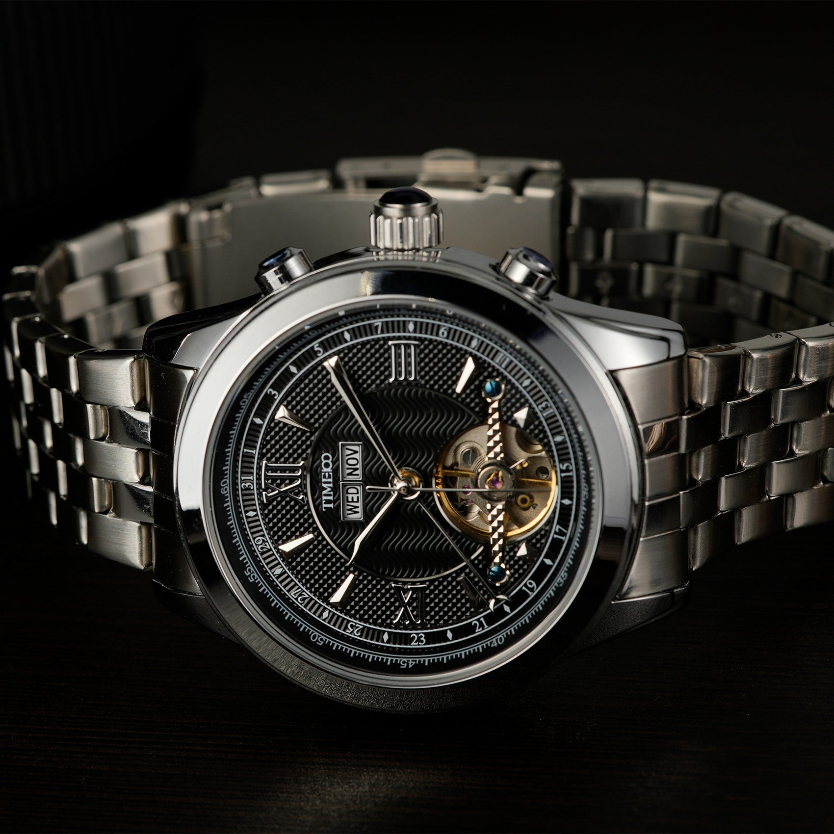 Close of TIME100 automatic watch face showing complex skeleton design, date, month, and week displays Silver Black - Time100