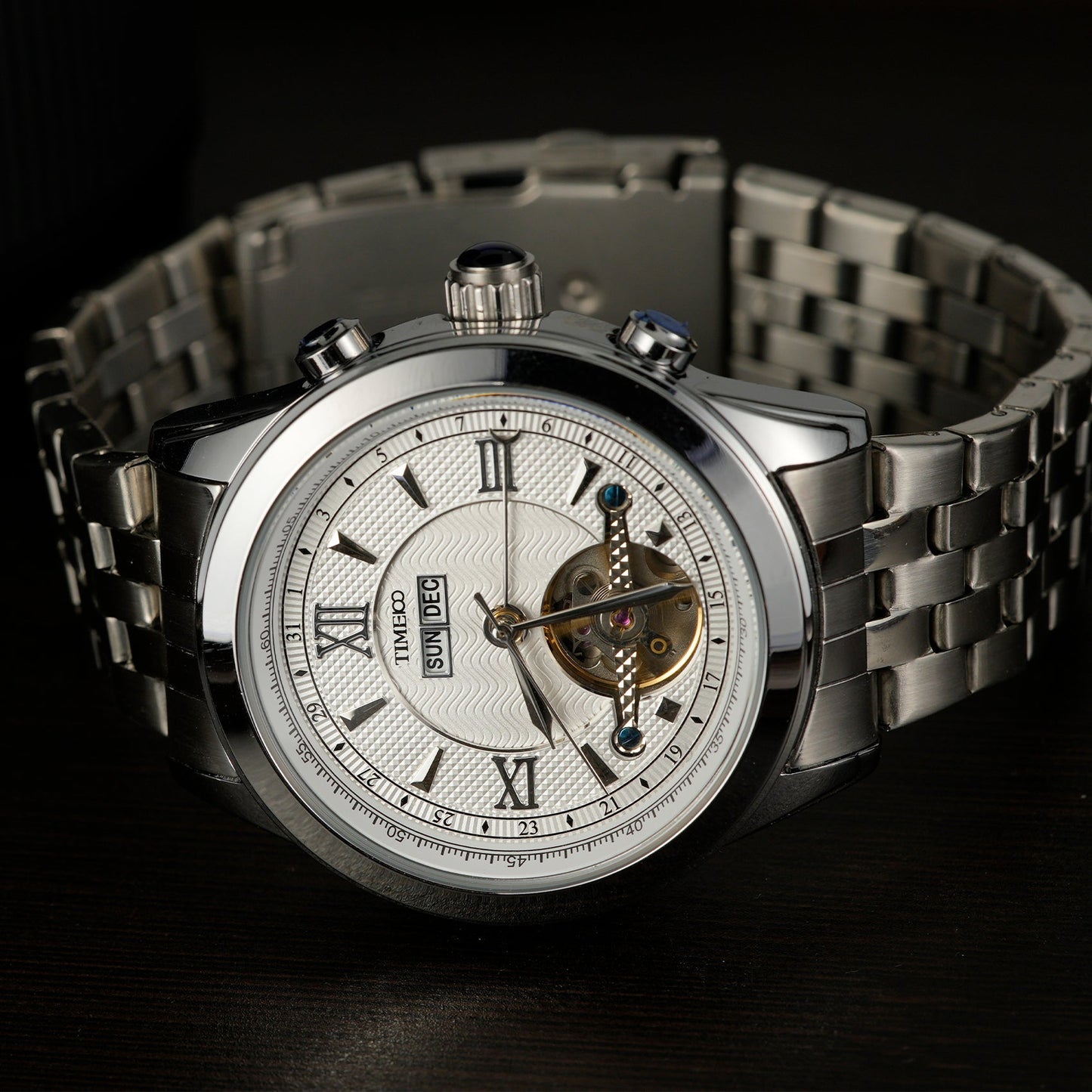 Close of TIME100 automatic watch face showing complex skeleton design, date, month, and week displays Silver White - Time100