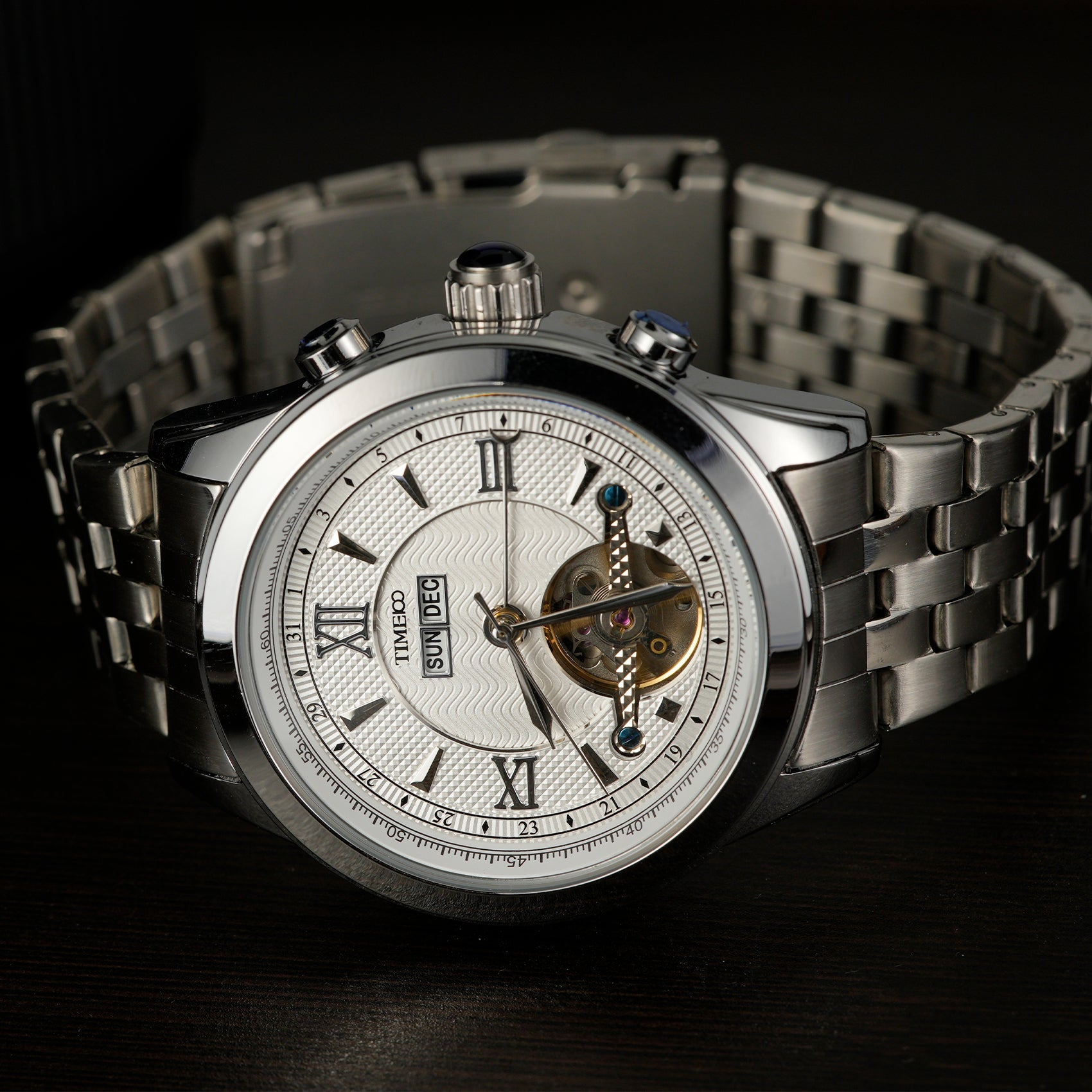 Close of TIME100 automatic watch face showing complex skeleton design, date, month, and week displays Silver White - Time100