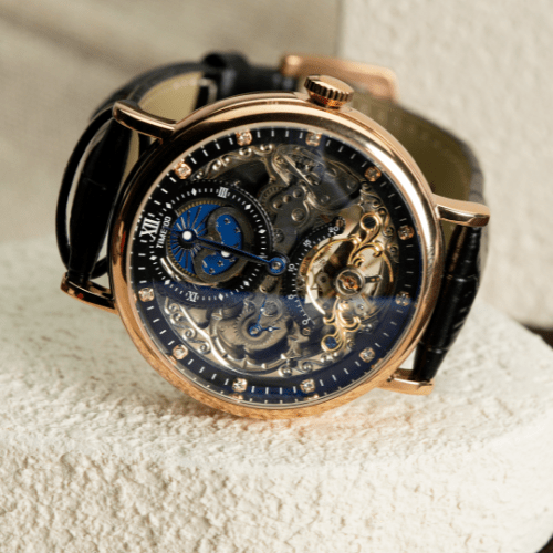 Close-up of the intricate self-winding mechanical movement and balance wheel on the TIME100 skeleton watch Brown - Time100