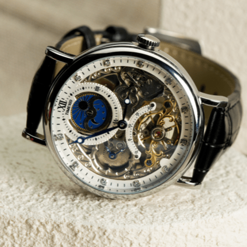 Close-up of the intricate self-winding mechanical movement and balance wheel on the TIME100 skeleton watch White - Time100
