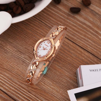 Sophisticated layered look with the TIME100 Soho rose gold-tone oval watch and matching bracelets on wrist Gold - Time100